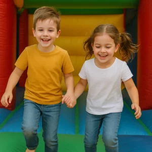 Zwei lachende Kinder beim gemeinsamen Spielen auf einer bunten Hüpfburg – Fairness und Rücksicht spielerisch lernen